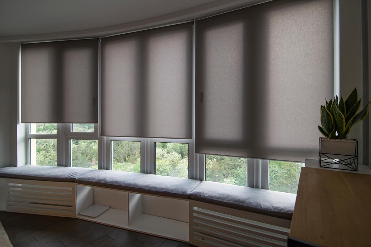 Automatic roller blinds beige color on big glass windows
