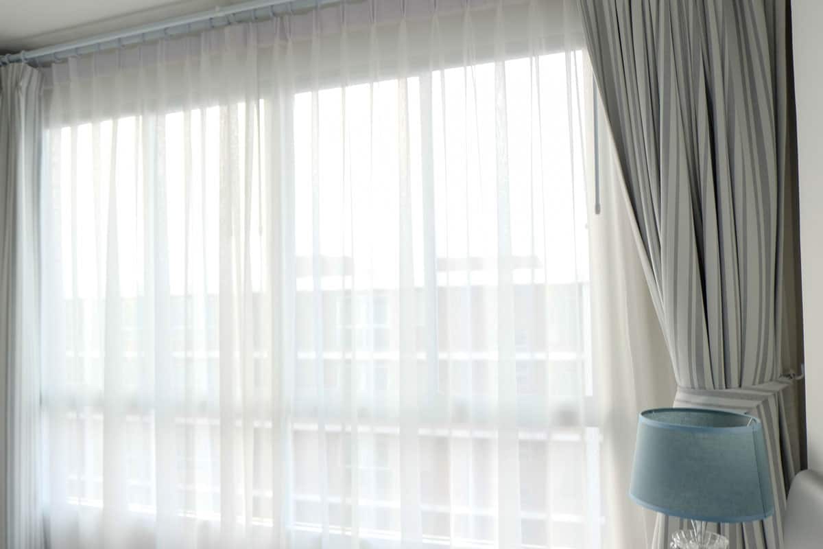 photo of a grey curtain with sheers on a huge wide window of the room on the hotel