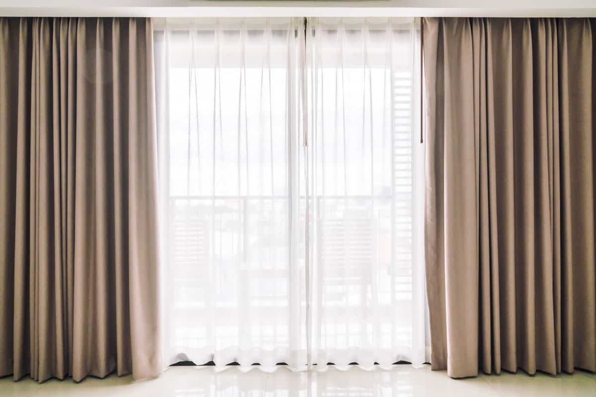 photo of a room curtain with same length and color brown curtain big window