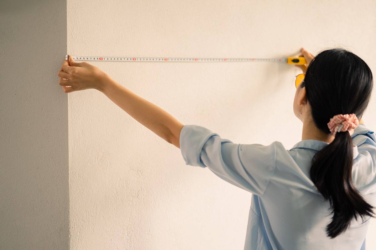 Measure the wall - Asian woman measuring the size of the wall