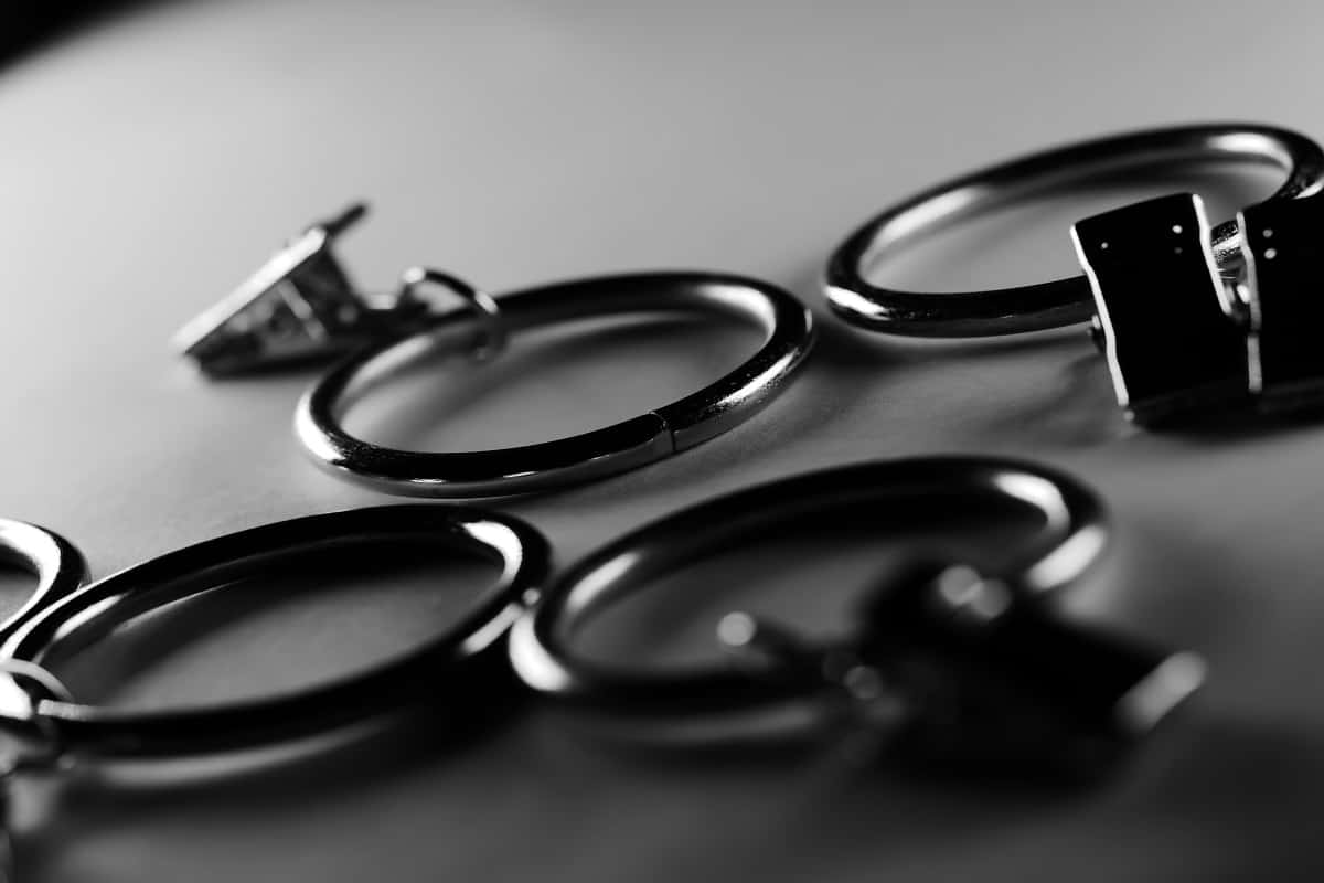 Attach the clips - A dramatic grayscale shot of curtain metal rod clip rings
