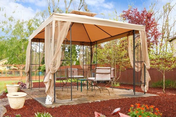 A backyard with flower beds, lawn and gazebo, How To Hang Curtains On A Metal Gazebo