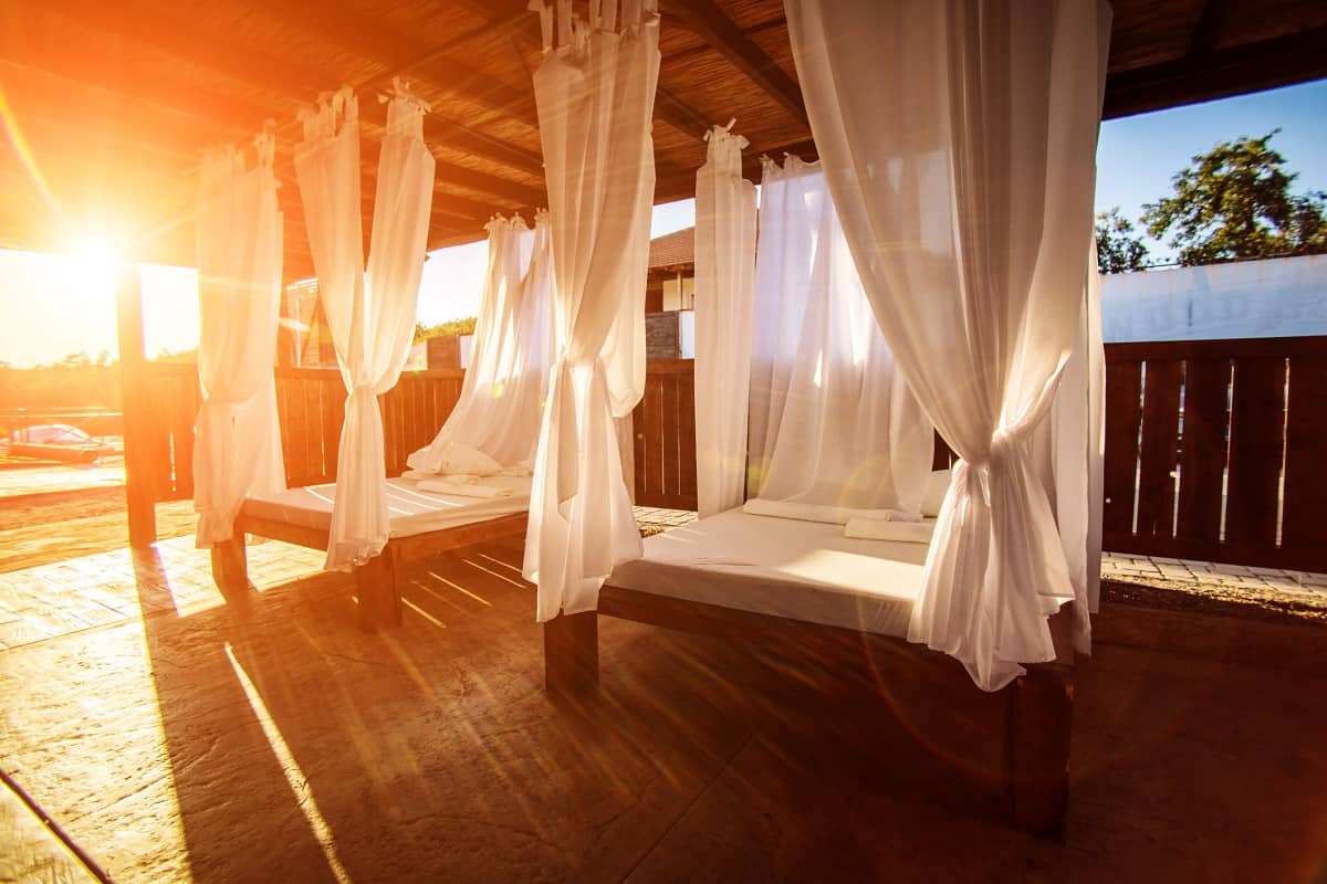 Fabric Type - Baldachin bed stock photo. Sunny canopy with a bed in a resort.
