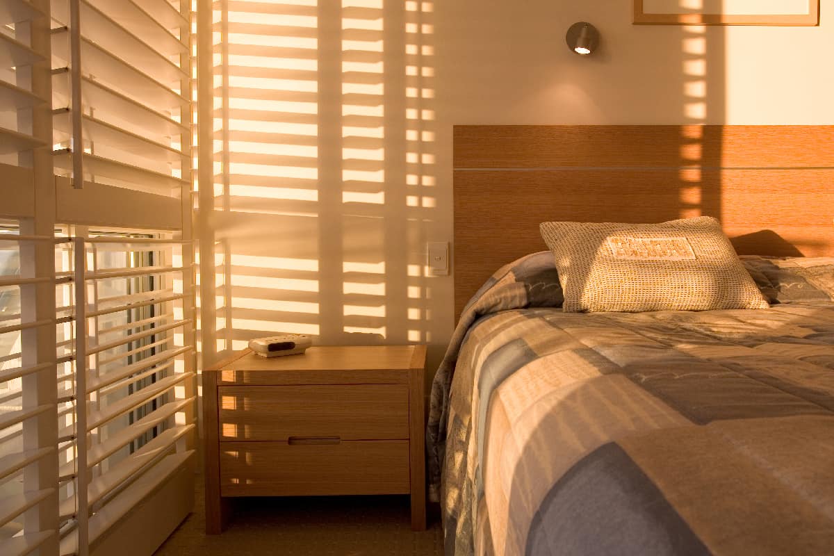 Beautiful golden light filtering through shutters in bedroom