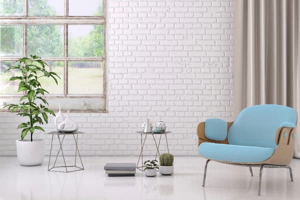 Blue colored armchair with coffee table, flowers and blank wall, How To Hang Curtains On A Brick Wall Without Drilling