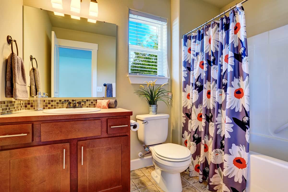 Do shower curtains need to touch the bathroom floor - Nice bathroom interior with modern cabinet and floral shower curtain.