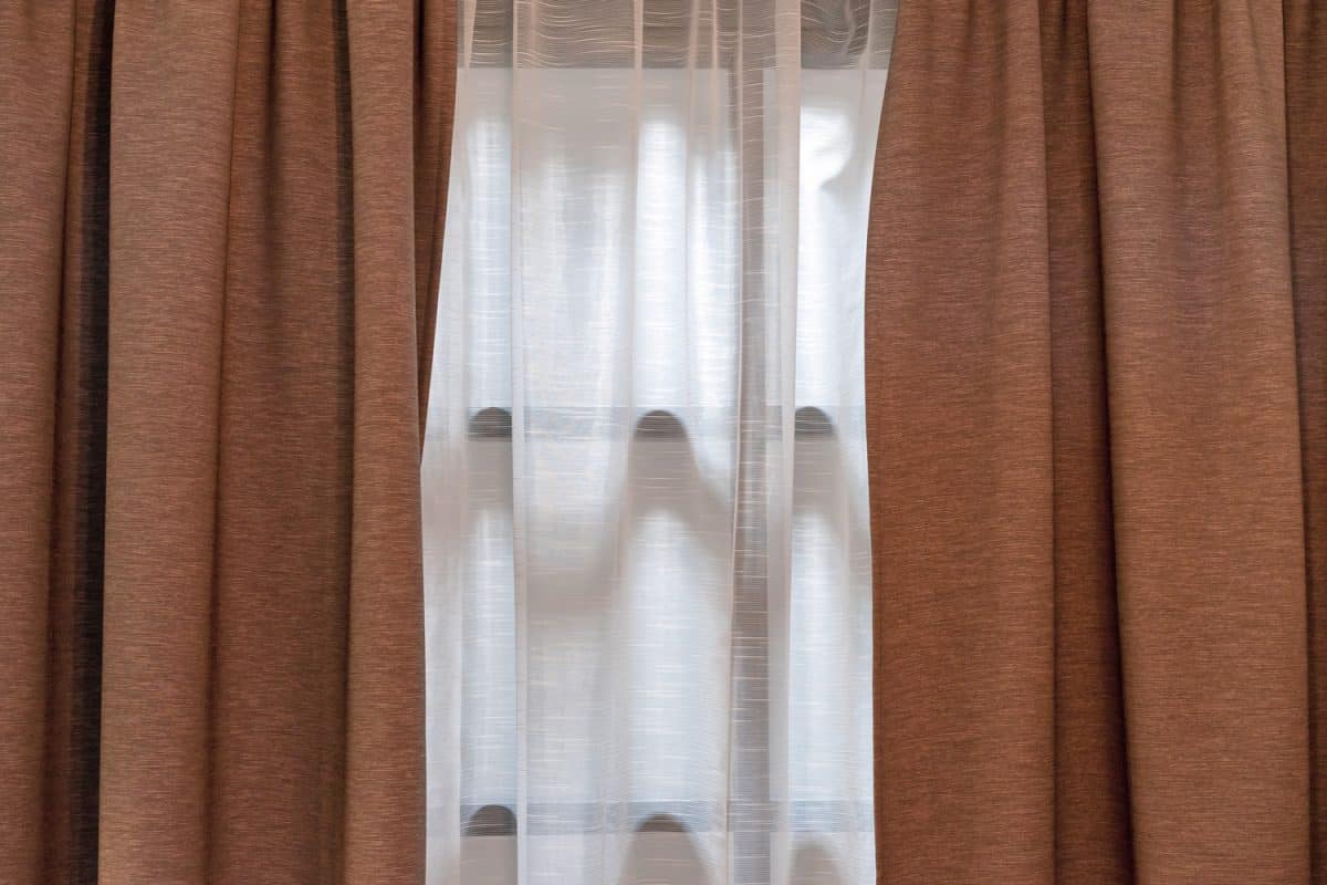 Double-layer curtains in brown blackout fabric and white tulle.
