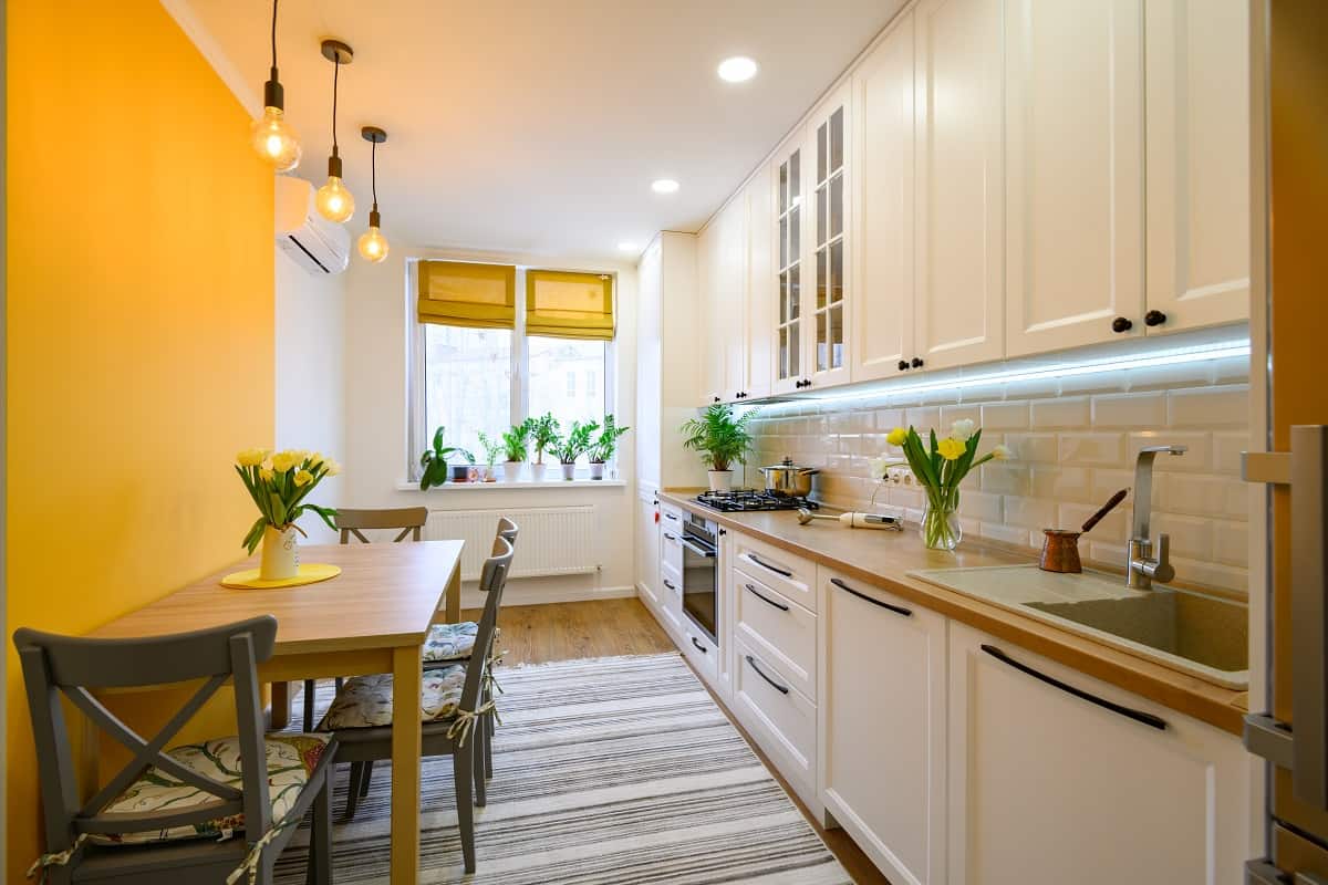 Go for Crisp Yellow Drapes - cozy well designed modern kitchen interior with appliances and dining table