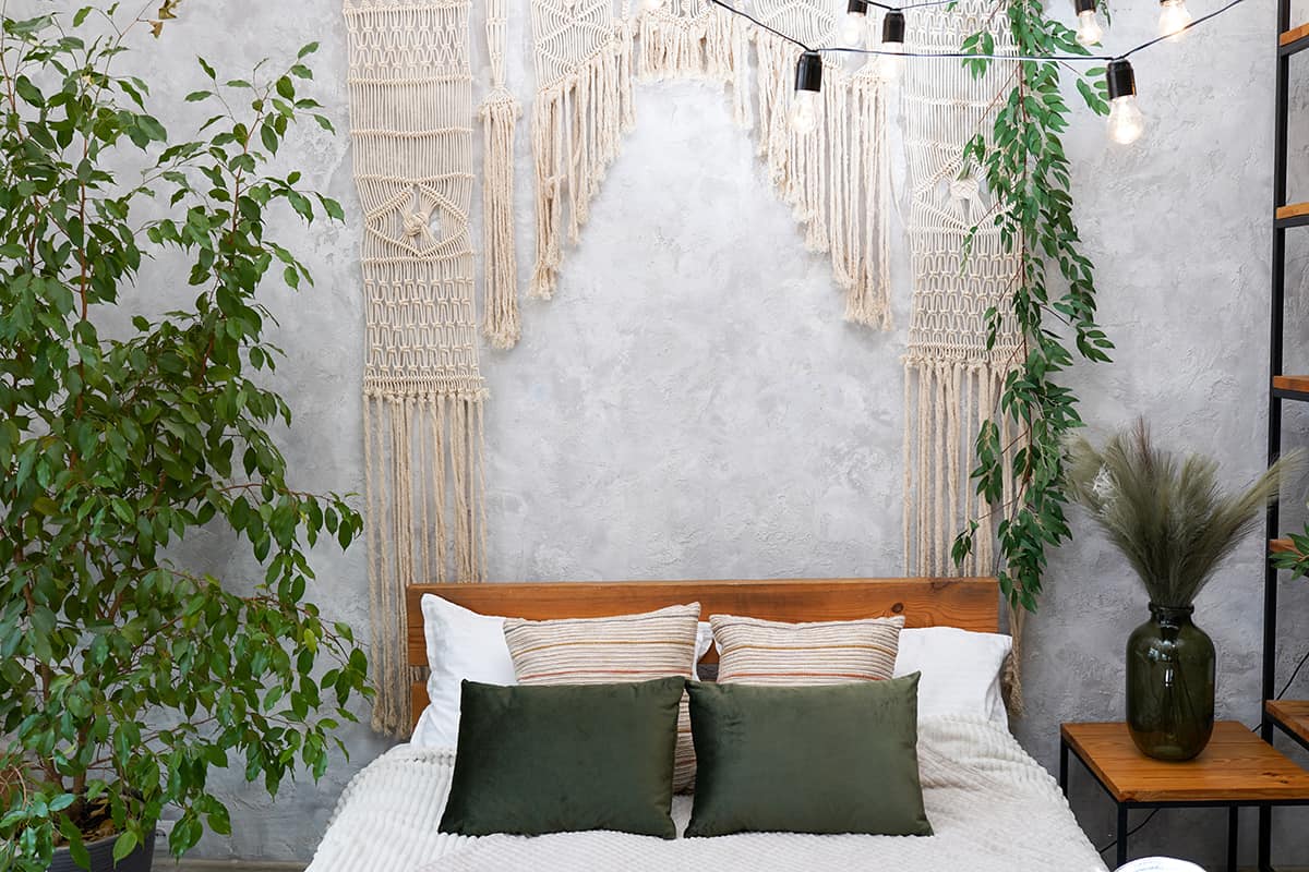 Green cozy scandinavian style bedroom interior with plants and macrame