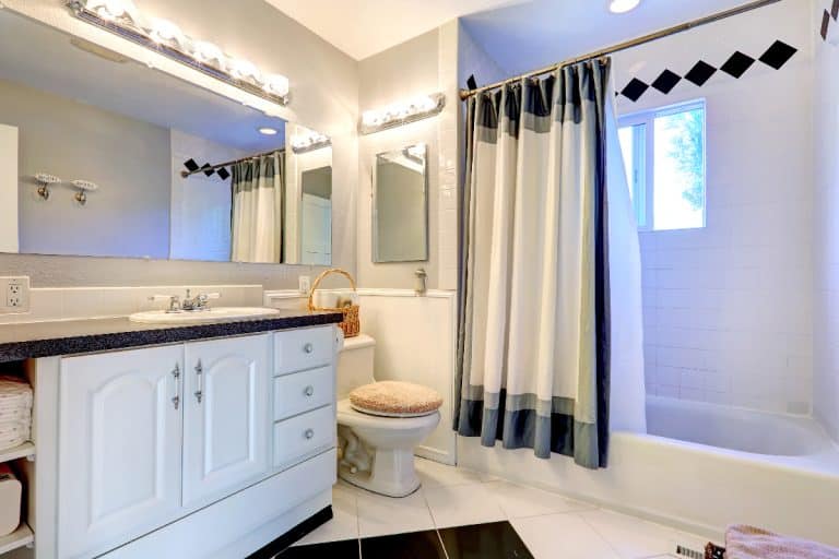 Refreshing bright bathroom with white cabinet, bath tub and white curtain, How Many Shower Curtains Do I Need?