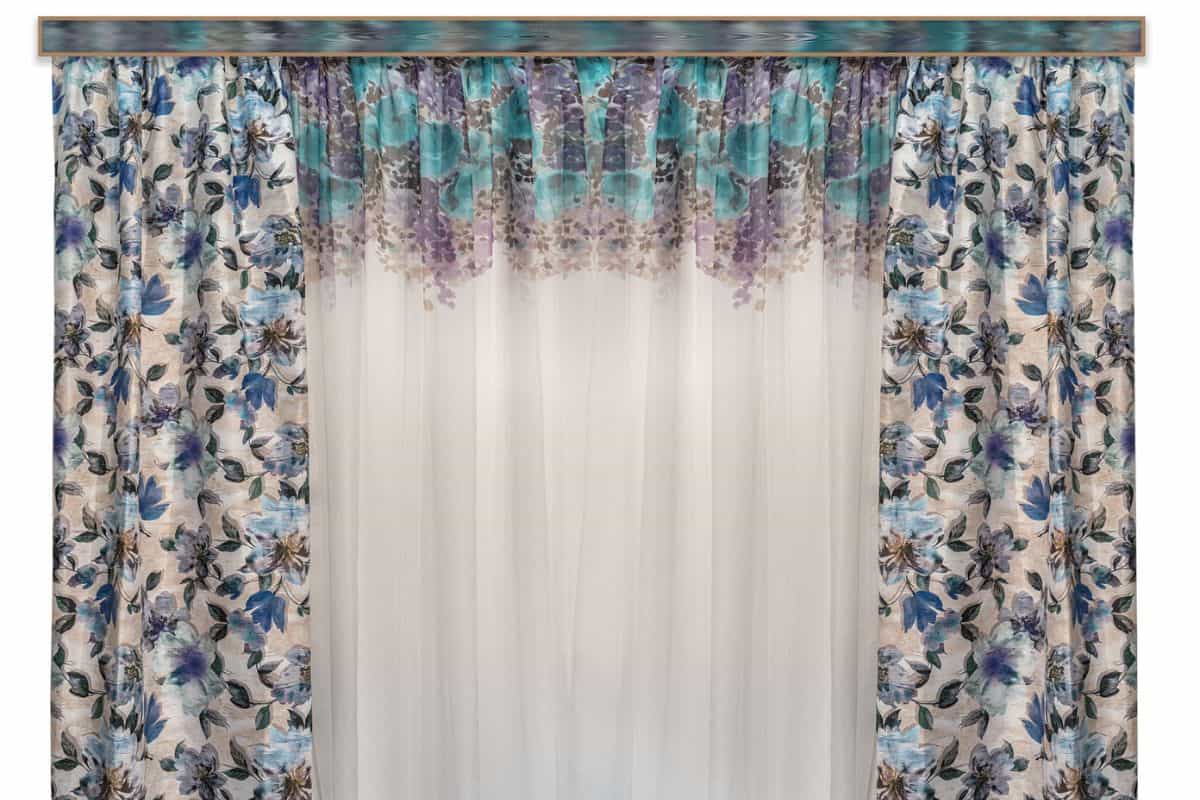 Straight curtains with a floral pattern on the fabric and a light tulle from thin transparent organza patterned on the top edge

