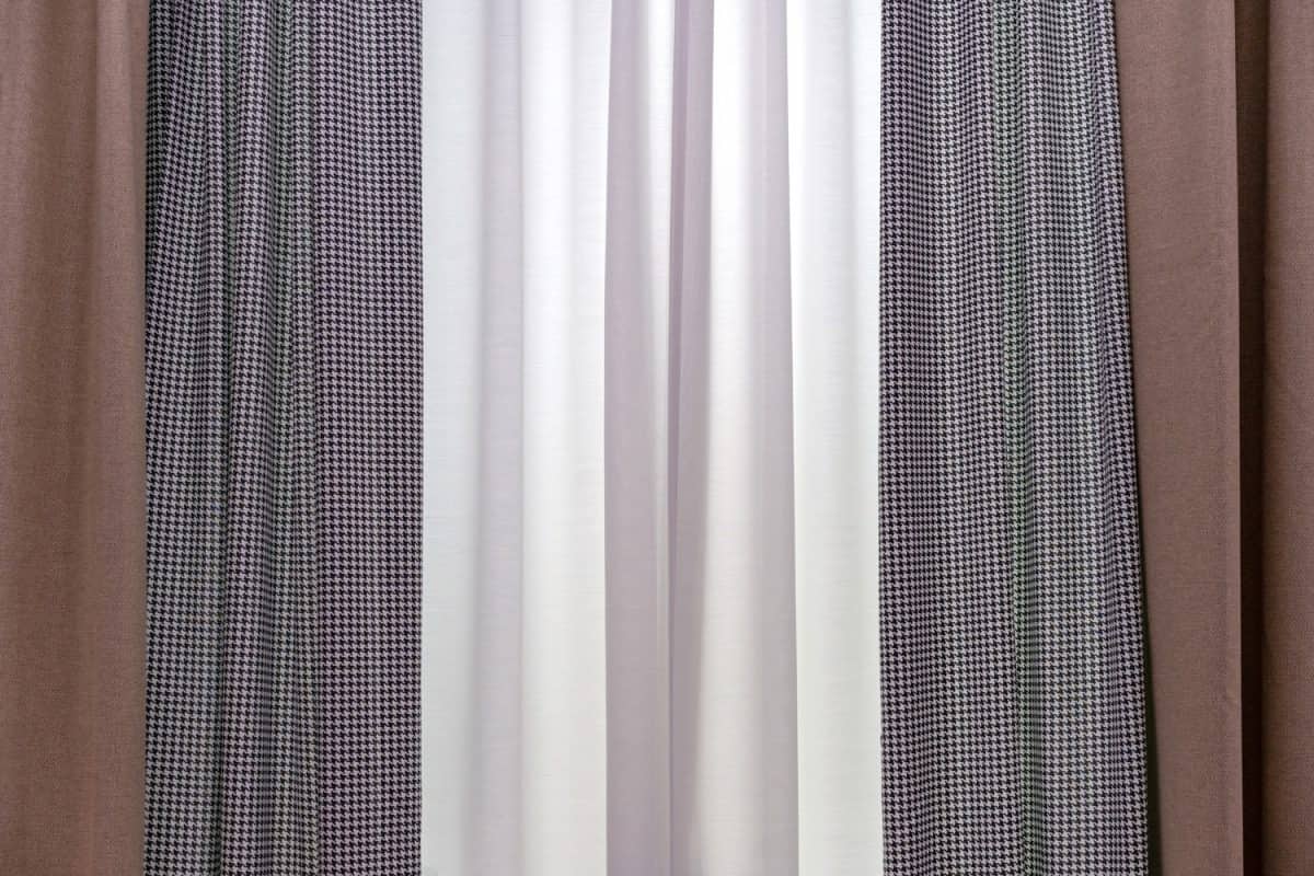 Three-layer curtains in brown fabric, white tulle and goose foot fabric.
