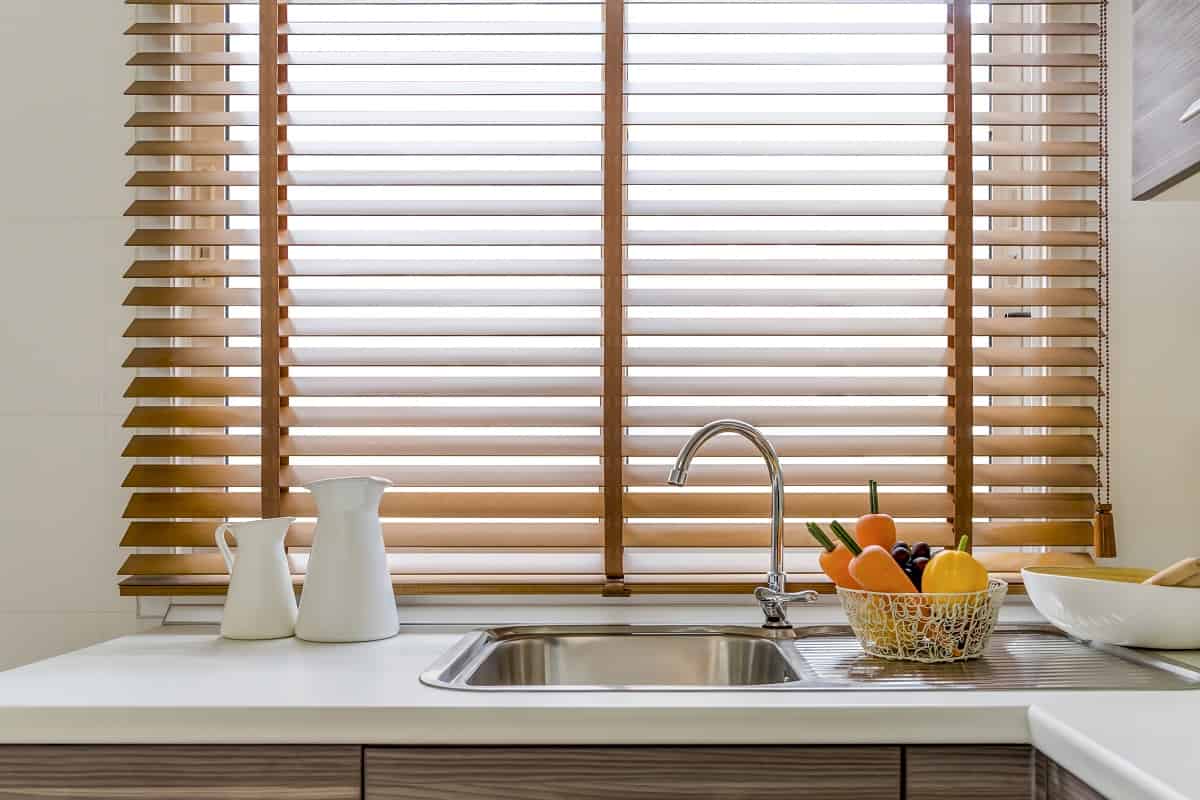 Use Wooden Blinds - Sink in the modern kitchen, windows decorated with wooden blinds