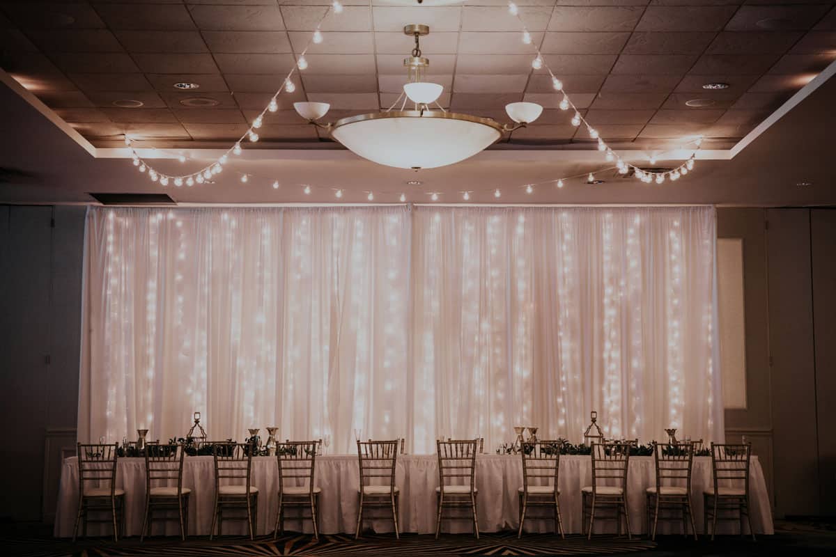 Wedding head table fairy lights on curtain