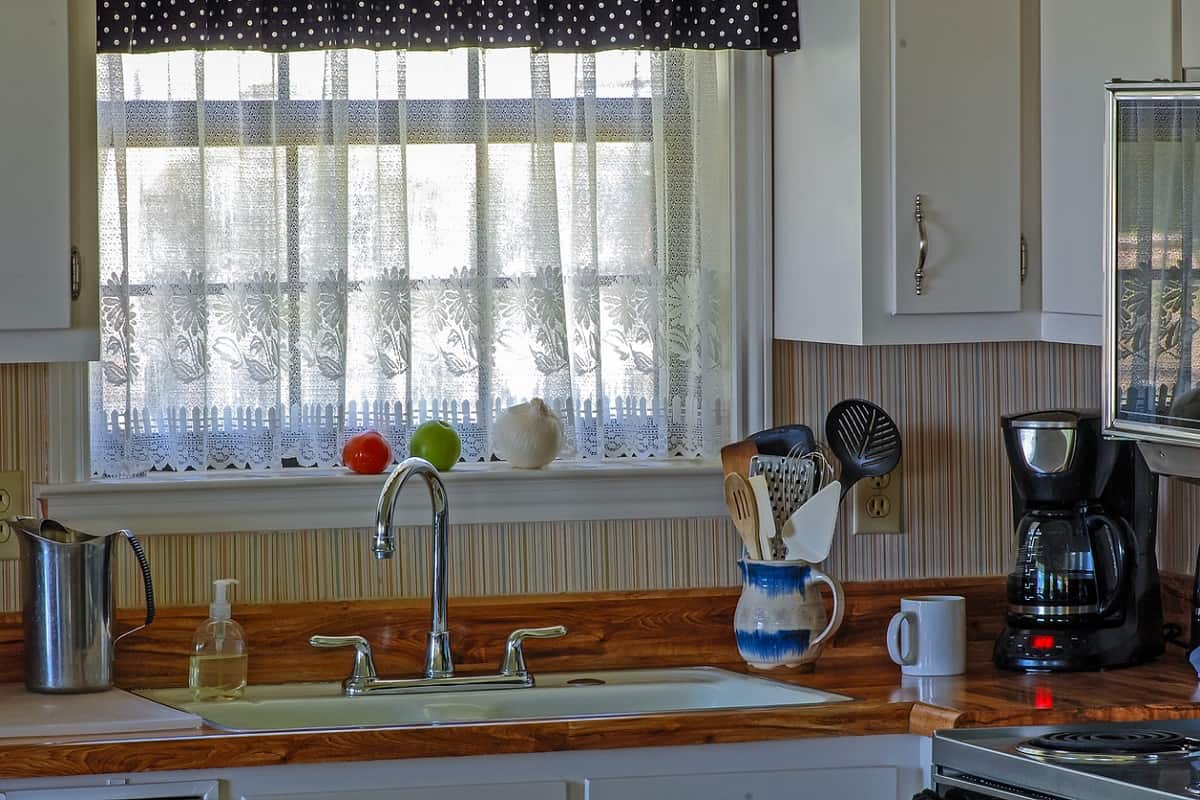 What To Do - Vintage kitchen with old fashioned porcelain sink, lace curtains and fruit and vegetables in the window,