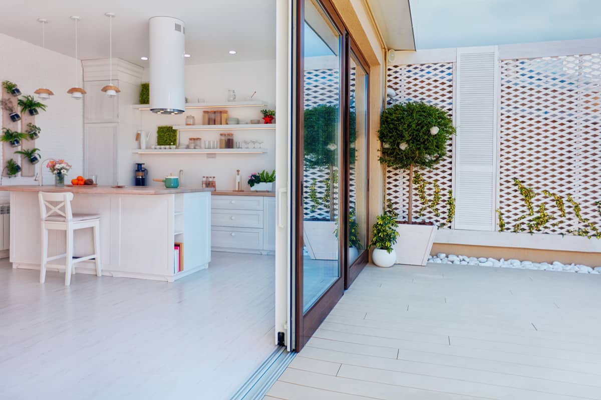 White modern kitchen with a huge sliding door leading to the patio