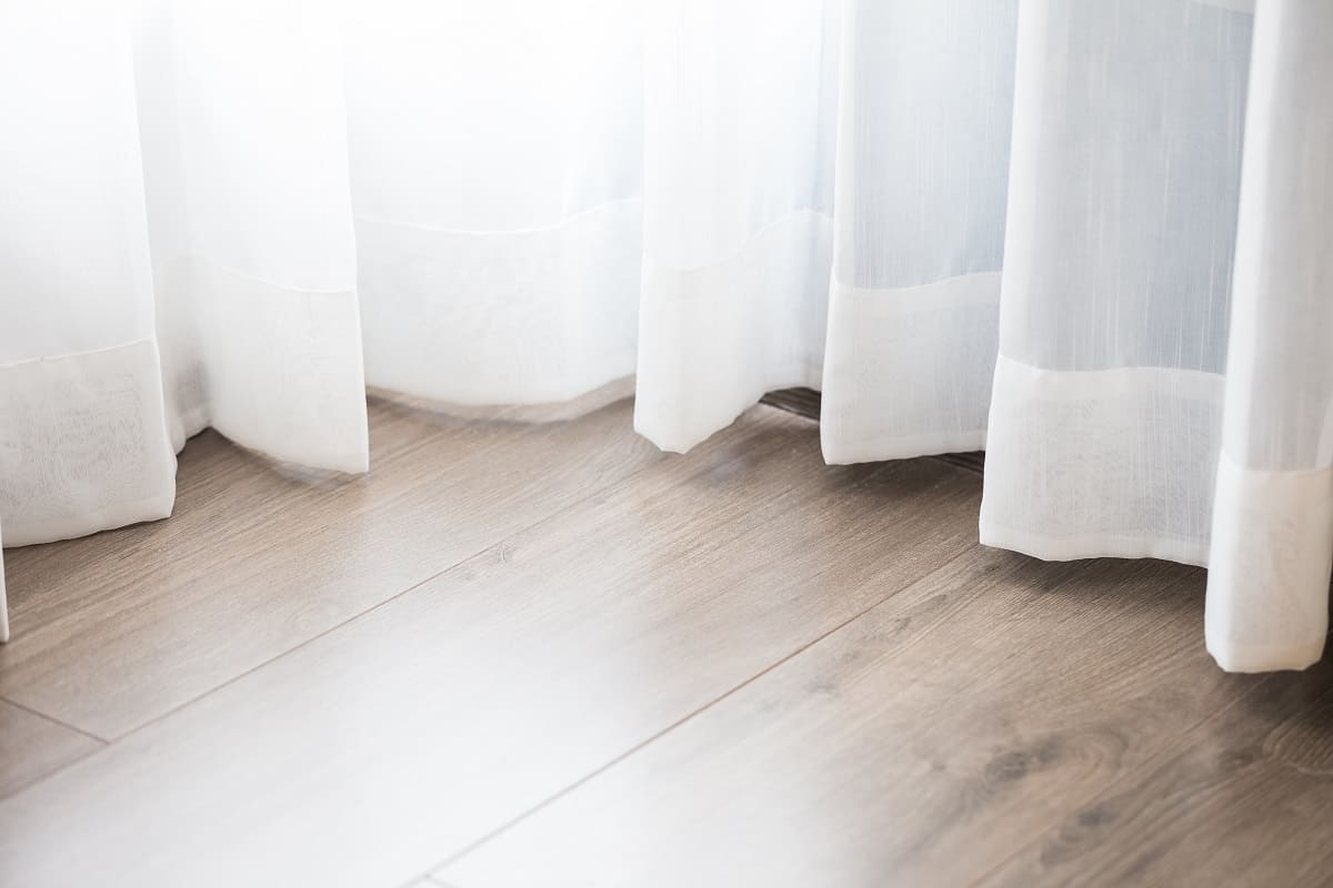 Window Treatments - bottom of transparent curtain on wooden floor