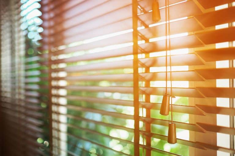 Wooden shutters blinds with sun rays, Do Blinds Block UV Rays?
