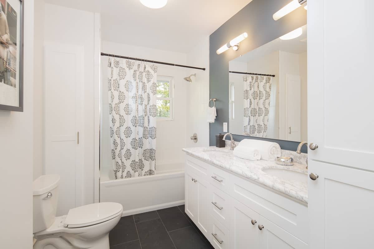 Wrapping It Up - Bathroom with double oval marble sink and shower curtain.