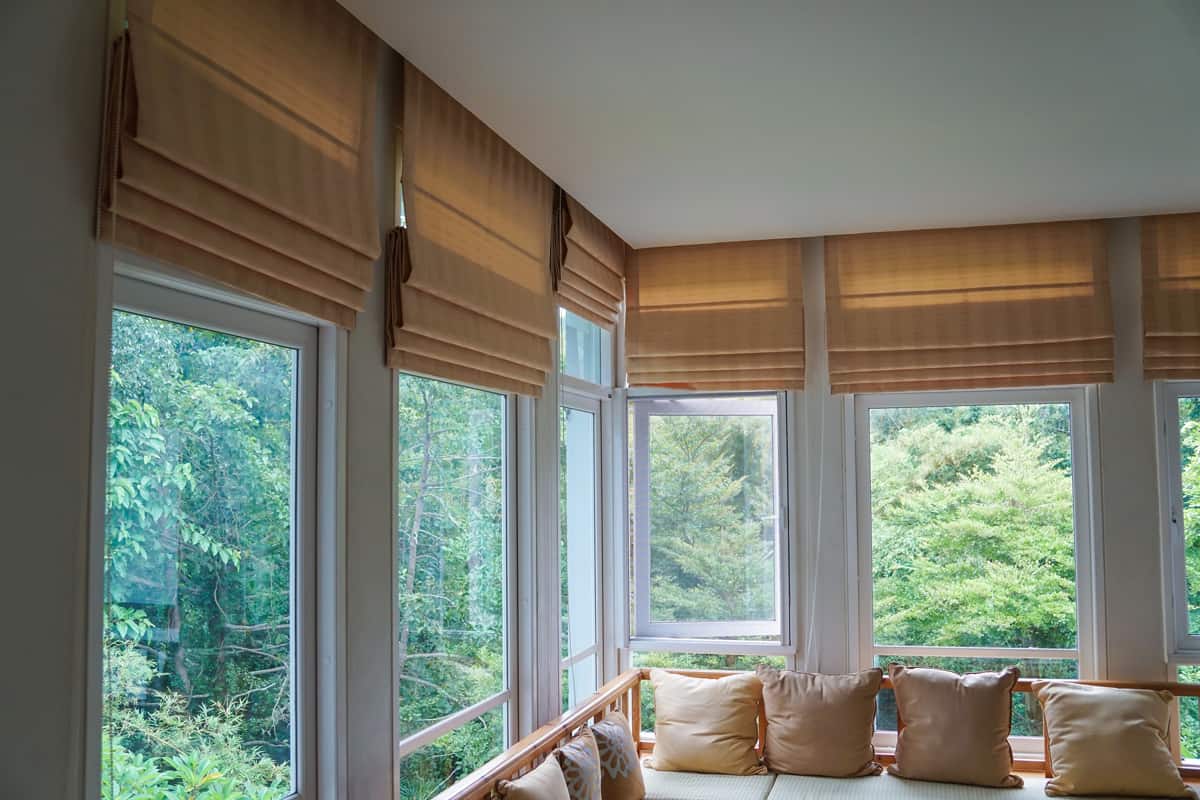 Brown roman blind shade curtain tree forest mountain background living room.