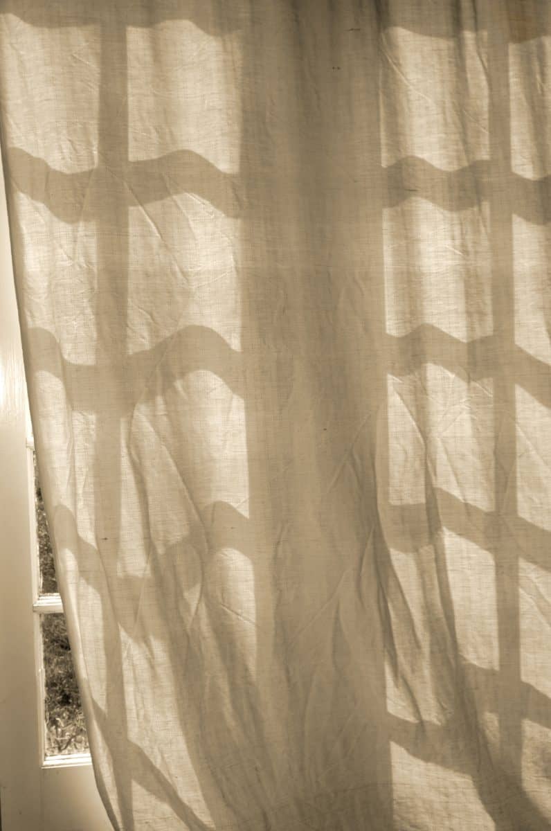 light brown curtain hanging in a white window