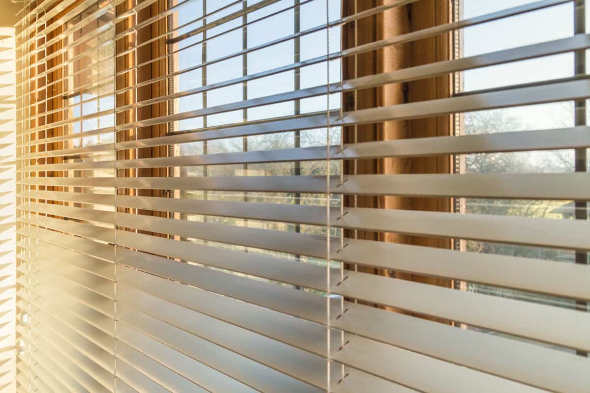 photo of a blinds-home-catching-sunlight outside the window