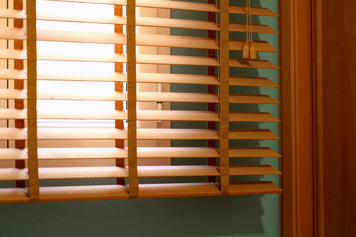 photo of a brown blinds venetian green wall sunny outside