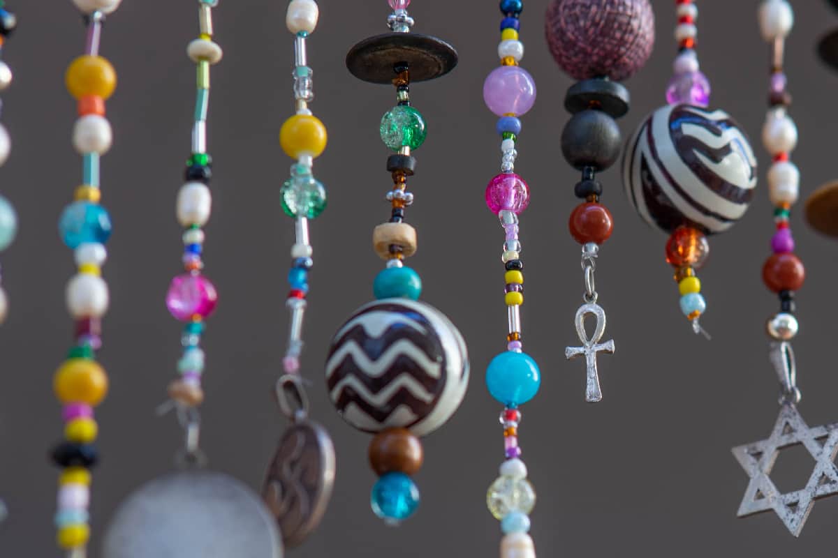 Modernist curtain of crystal beads of different colors and pendants with different symbols