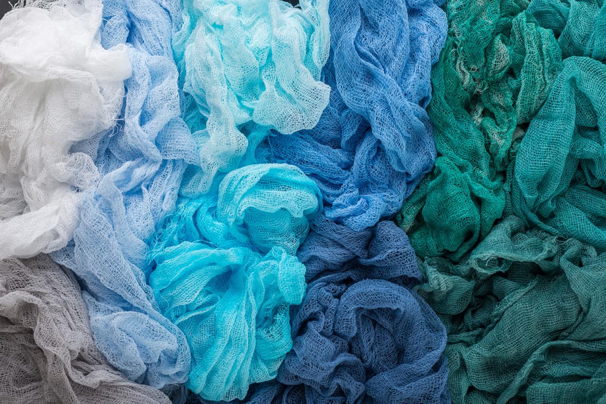 Multicolored background of blue, blue, green, blue-salted, turquoise colors of gauze fabric.