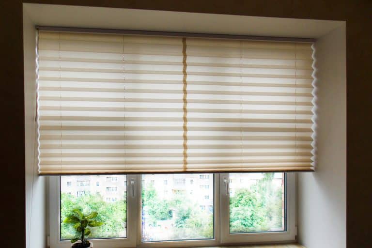 Pleated blinds XL, beige color, with 50mm fold closeup in the window opening in the interior. Home blinds - modern bottom up privacy shades half raised on apartment windows. - How Wide Should Blinds Be Inside Mount