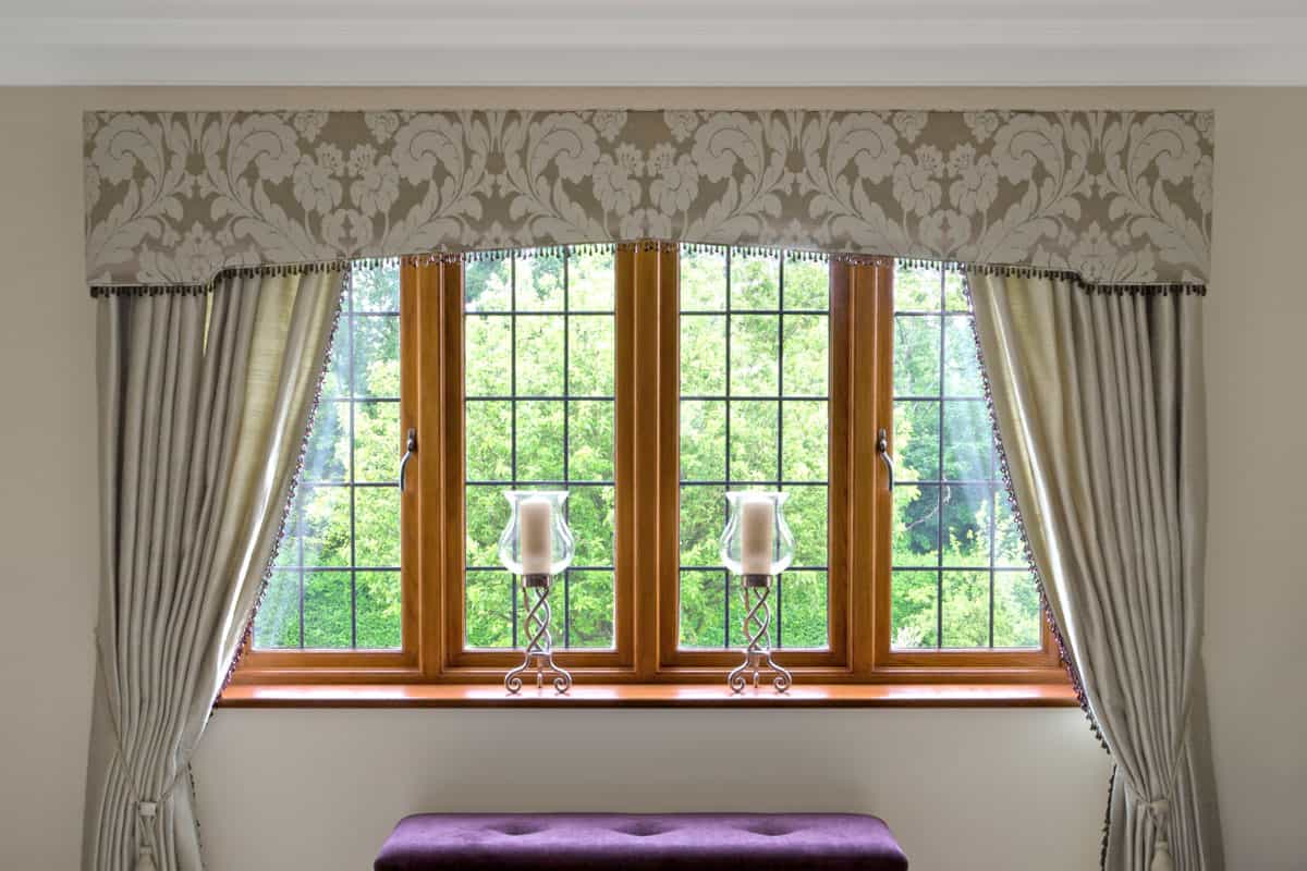 a bedroom window dressed with silk curtains in an expensive luxury new home. The decor has been prepared